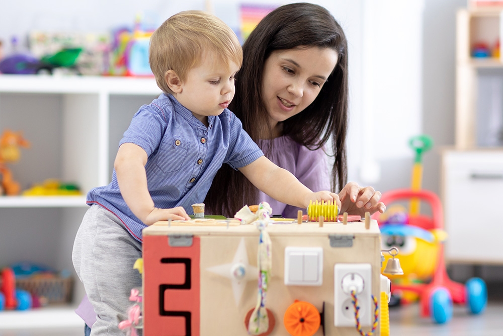 Child playing with stacking cubes on a table