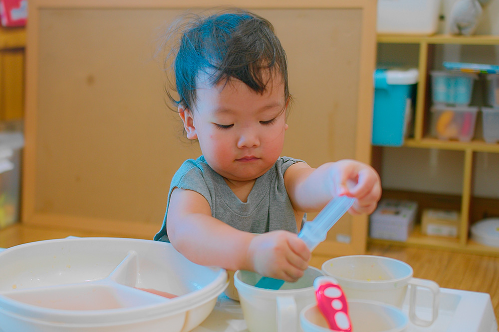 A toddler happily experimenting, showcasing playful interaction in a playful environment