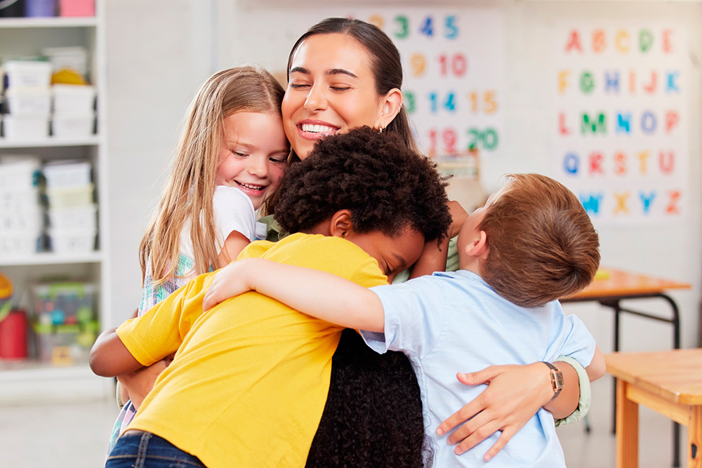 A teacher embraces children in a classroom, fostering a warm and supportive learning environment.